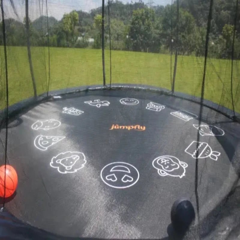 Jumpfly trampoline with colorful cartoon mat and safety net in a grassy backyard